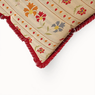 A close-up of the Bela Fringes cushion cover, highlighting the red fringe texture and the intricate floral pattern on the fabric.
