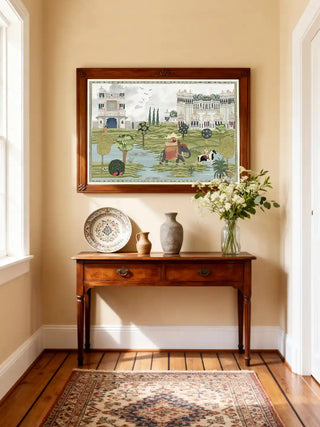 Bharat palace and peacock wall art in sage ivory, framed in warm wood above a cherry console table with a painted platter, stone vase and white blooms in a sunlit foyer.