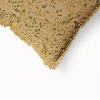 A close-up of the "Bird Tapestry Fringes" cushion cover, highlighting the detailed leaf and floral patterns, a glimpse of the bird, and the natural-toned fringed border.