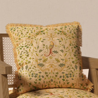 The "Bird Tapestry Fringes" cushion cover styled on a light wooden chair, showcasing its classic design and how it enhances a rustic or traditional decor.