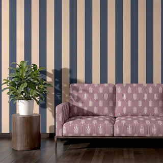 Bloomark upholstery fabric in dusty rose on a two-seater sofa, set against navy and cream striped walls in a living room.