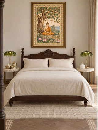 Bodhi Serenity wall art in a carved gilded frame above a dark wood bed with cream linen bedding and marble-topped side tables in a bedroom