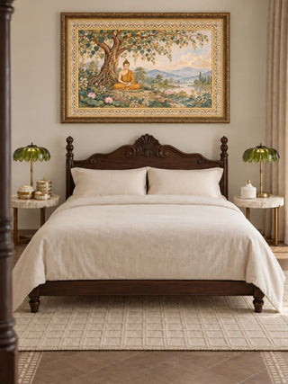 Bodhi Serenity wall art in a carved gilded frame above a dark wood bed with cream linen bedding and marble-topped side tables in a bedroom