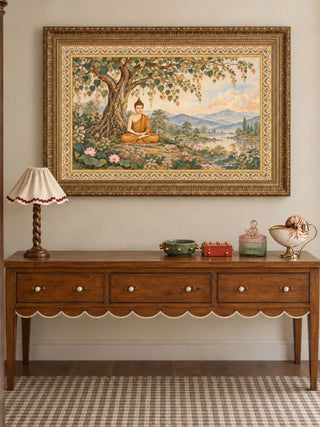 Bodhi Serenity wall art in an ornate antique-gold frame above a walnut console table with three drawers, a scalloped apron and a ruffled lamp