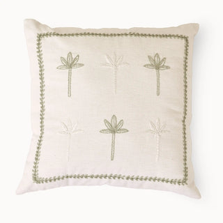 A top-down view of the Botanical Stitch cushion showcasing the hand-embroidered palm motifs and leafy border on a cream base.