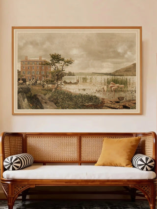 Britannia Oasis landscape art framed in natural wood, styled above a classic cane sofa with a mustard cushion.