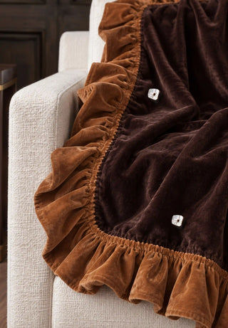 A close-up of the Caramel Truffle sofa throw showing the ruffled caramel border and faceted stud embellishments.
