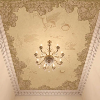 The Celestial Veil antique beige custom mural styled on a dining room ceiling behind a classic brass chandelier.