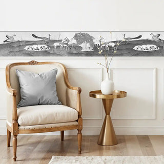 The Chandni Van charcoal wall border styled above white wainscoting and a French-style bench.