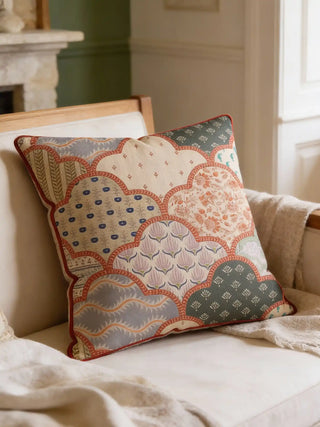 A luxury Chhap cushion cover with scalloped block-print motifs placed on a cream linen sofa in a sunlit living room.