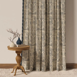 The Chhaya Fringes curtain hanging, showcasing its soft, square-patterned design in muted blue and beige with a textured fringe.