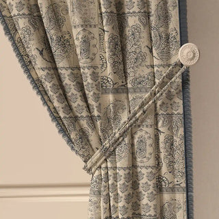A close-up of the Chhaya Fringes curtain tied back with a tasseled cord, highlighting the elegant drape and the details of the fabric.
