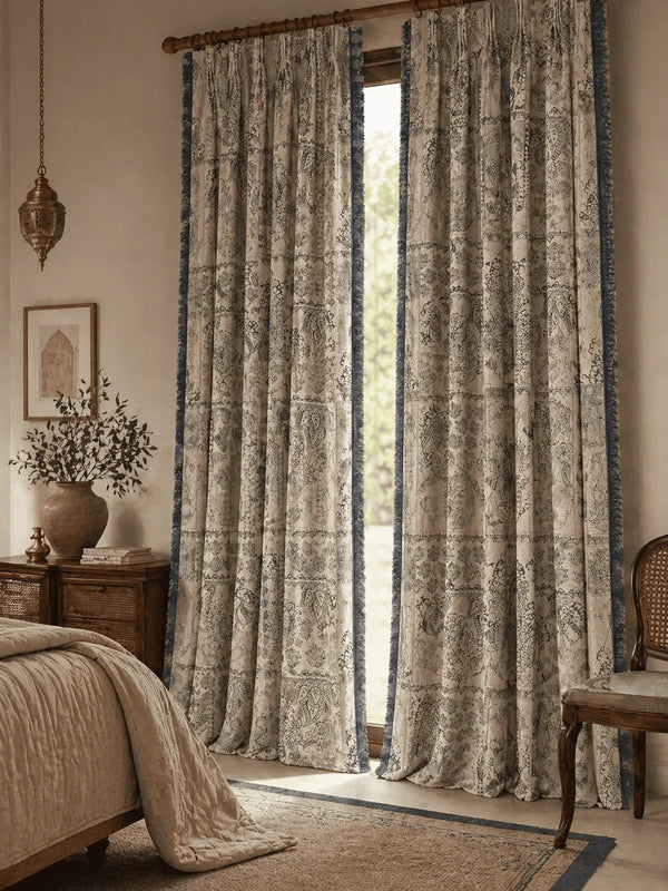 Decorative chhaya Indian curtains in a room with a bed and side table.