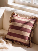The Cinnamon Stripe Ruffle linen cushion cover styled as a classic accent on a plush cream contemporary sofa.