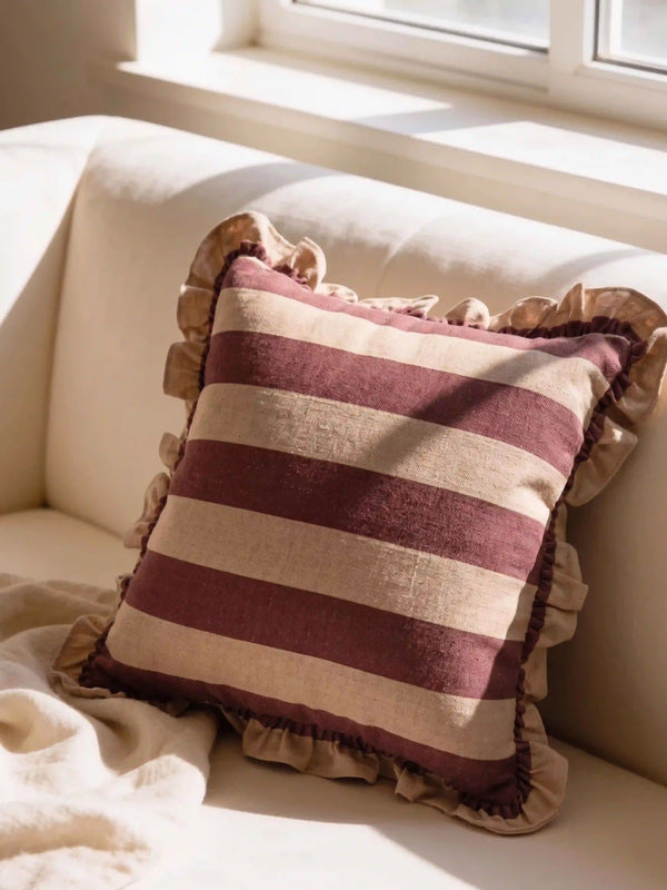 The Cinnamon Stripe Ruffle linen cushion cover styled as a classic accent on a plush cream contemporary sofa.