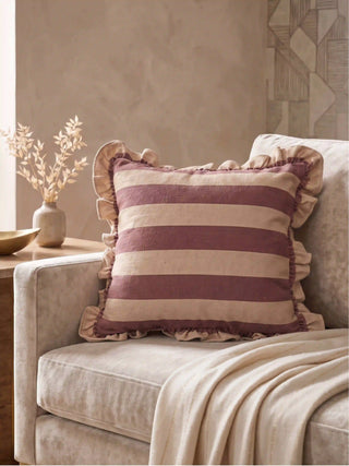 The Cinnamon Stripe Ruffle linen cushion cover styled as a classic accent on a plush cream contemporary sofa.