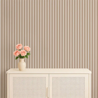A beige and cream striped wallpaper applied behind a cream cabinet with a vase of pink roses, creating a soft and elegant look.