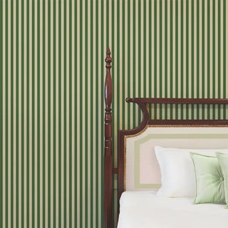 A green striped wallpaper behind a wooden bed with white and green bedding, adding freshness and elegance to the room.