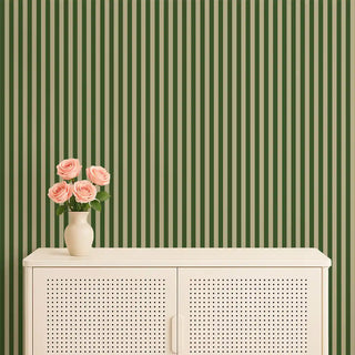 Green & green striped wallpaper styled behind a cream console with a vase of pink roses, blending nature-inspired tones with soft décor.