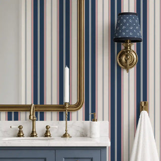 Classic Navy Pinstripe wallpaper behind a brass-fitted bathroom vanity with a marble countertop