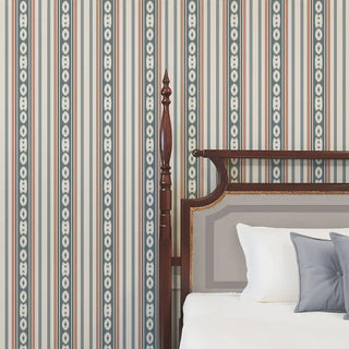 The blue and cream striped wallpaper applied behind a classic wooden bed, creating a timeless interior.