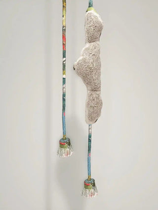 A high-resolution close-up showing the ribbed silver cord embroidery on the cloud emblem and a hanging multi-colored tassel.
