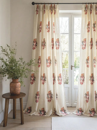 Symmetrical styling of the Cotswold Rose custom drapery adding romantic heritage charm to a cottage-style living room with exposed wood beams.