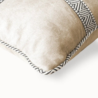 Close-up of the beige velvet cushion corner showing the patterned piping.