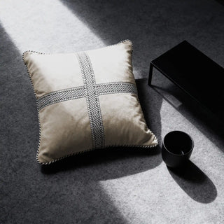 Single Cross Weave Cushion Cover displayed on a grey floor next to a black table.