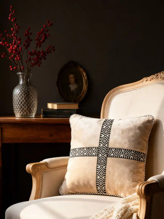 A Cross Weave cushion styled on a classic cream-colored French armchair in a moody interior.