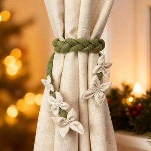 Decorative curtain tieback with braided design and floral elements against a blurred festive background from lifencolors
