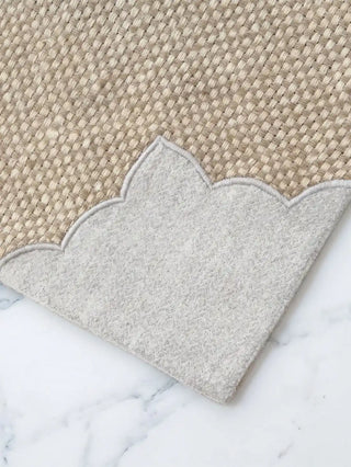 A close-up view showing the rich contrast between the woven jute paneling and smooth linen on the Dar Alia table mat.