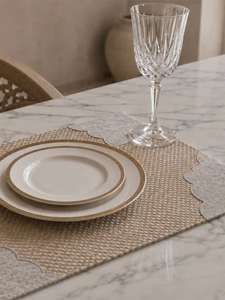 A close-up view showing the rich contrast between the woven jute paneling and smooth linen on the Dar Alia table mat.