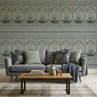 A contemporary living room featuring the Dastaan blue mural behind a grey sofa with sage green cushions.