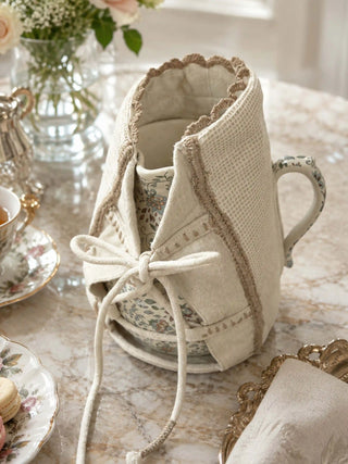 Deep Lore jug cover styled on a marble tea table with fine china teacups, silver teapot, and fresh roses