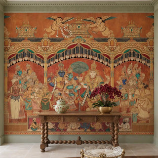 The Deva Sabha wallpaper in Terracotta & Gold behind a carved wooden console table with a patterned jar and a bowl of dark red orchids.