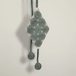 Close-up shot of the Forest Orbit Holdback hanging, highlighting the textured ball ends and the geometric pattern of the central piece.