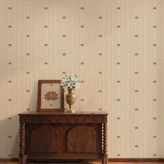 The Doriya subtle beige striped wallpaper styled in a foyer behind a dark carved wooden console table with a brass flower vase.