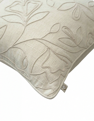 A high-resolution close-up of the raw ivory linen canvas weave and raised corded botanical vine embroidery on the Eden cushion cover.