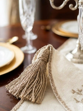 A detailed flat lay view of the corner design on the Eden placemat, showcasing the open-mesh border and embroidered twig.