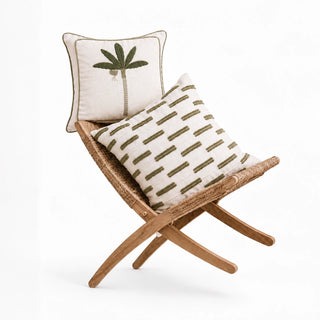 Eka Kanan and Ari cushion covers on a rattan folding chair, a sage palm beside olive tufted stripes