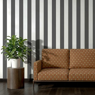 Sofa upholstered in Ekani Fabric set against bold black and white striped wallpaper.