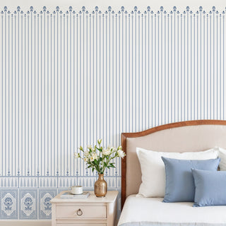 Close-up of the blue and white striped wallpaper and lower floral panel border installed in a chic bedroom.