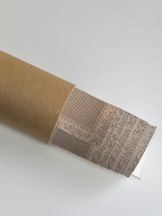 Real embroidered textile art rolled carefully into a protective shipping tube.