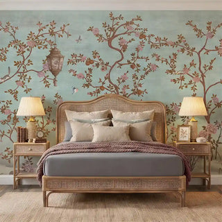A sophisticated bedroom featuring the Enchanted Glade blue mural behind a rattan bed frame and neutral linens.