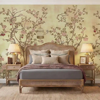 A sophisticated bedroom featuring the Enchanted Glade wallpaper behind a rattan bed frame with neutral linens.