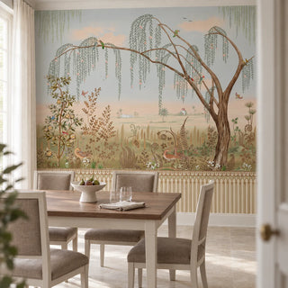 The Enchanted Grove multicolor wallpaper mural with a weeping willow and ferns above an arched trellis dado, framing a walnut dining table and linen chairs view-dining