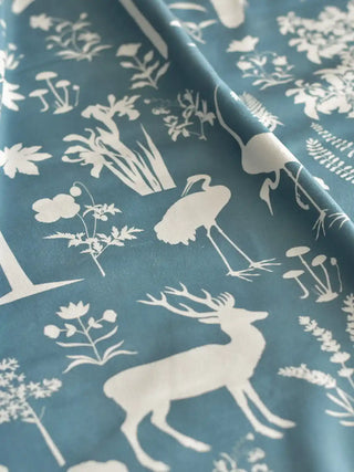 A flat lay swatch of Flora n Fauna upholstery velvet in blue and white, highlighting the crisp botanical patterns and plush texture.