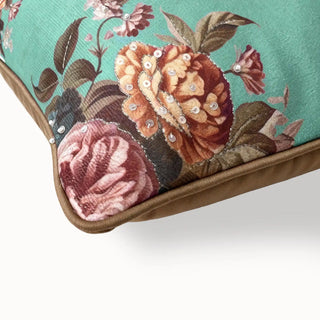 Close-up of the teal cushion corner showing the floral print, sequins, and piping.
