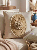 A lifestyle view of the Florence Frieze cushion styled on a beige sofa next to dried pampas grass.